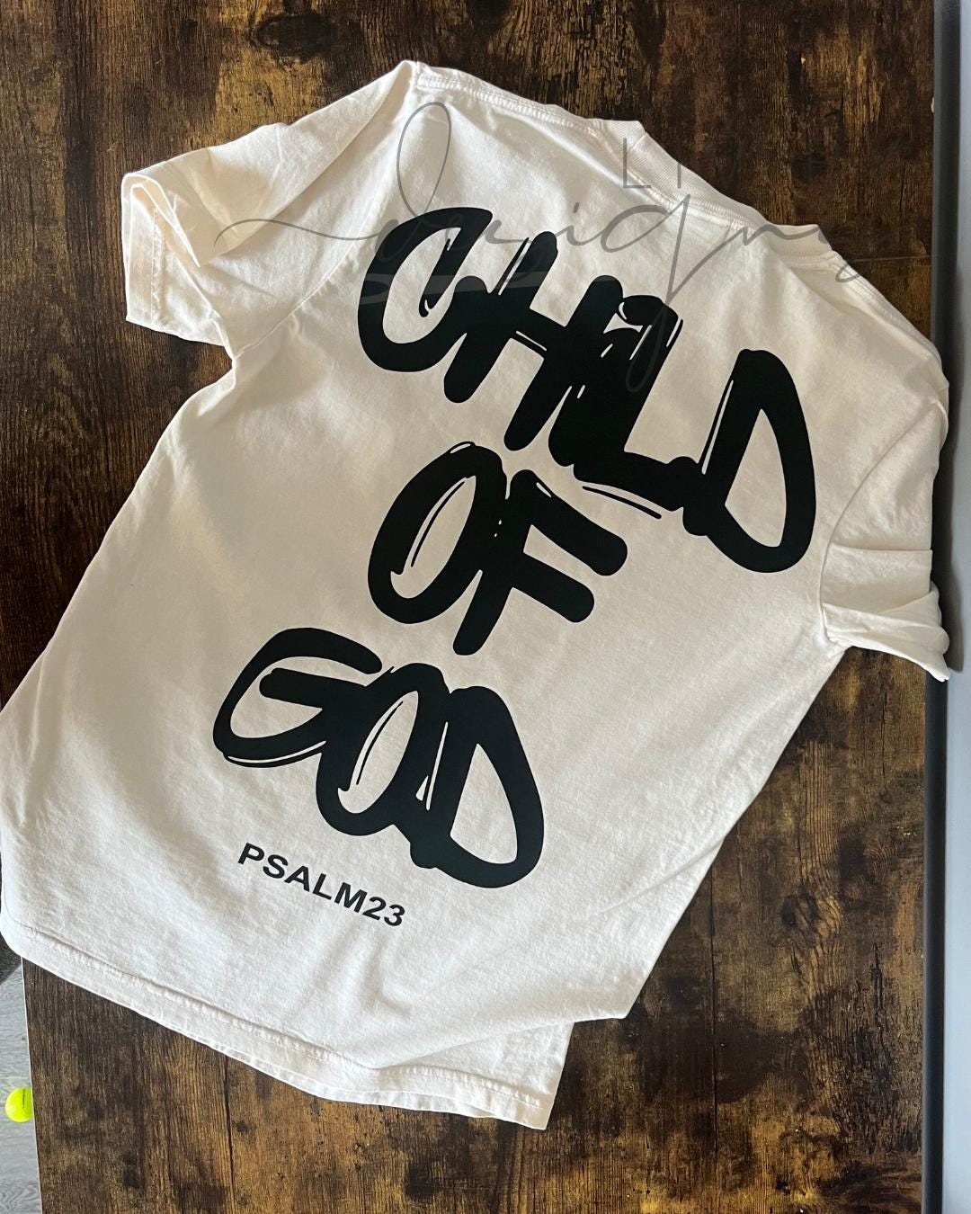 Back view of ivory Comfort Colors tee with large “Child of God – Psalm 23” DTF print
