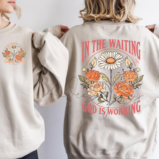 Christian faith-based crewneck sweatshirt featuring floral artwork and the phrase “In the Waiting, God Is Working” inspired by Isaiah 40:31, shown on a neutral Gildan Heavy Blend sweatshirt.
