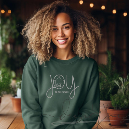 Woman wearing forest green Joy to the World nativity crewneck