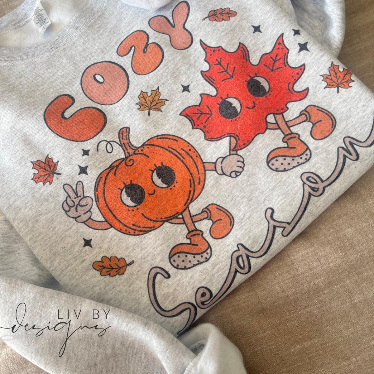 Fall sublimated Cozy Season sweater folded for display. (etsy image id: 6765536514)