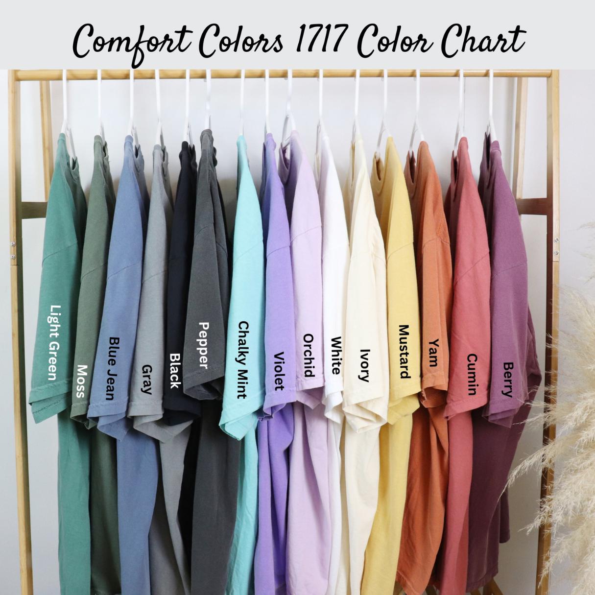 Comfort Colors 1717 Color Chart showing 14 different t-shirt colors hanging on a rack. The colors are: Light Green Moss, Blue Jean, Gray, Black, Pepper, Chalky Mint, Violet, Orchid, White, Ivory, Mustard, Yam, Cumin, and Berry. (etsy image id: 6812097383)