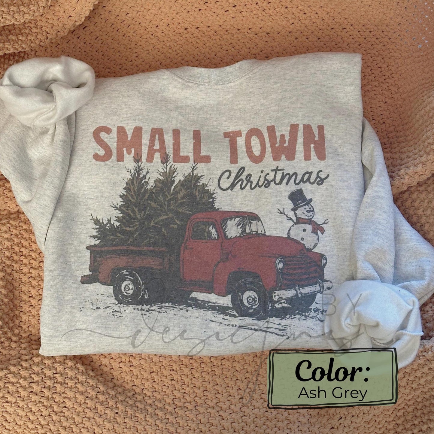 Close-up of Small Town Christmas sweatshirt showing retro red truck and snowy holiday scene on ash grey fabric (etsy image id: 7431642318)