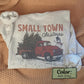Close-up of Small Town Christmas sweatshirt showing retro red truck and snowy holiday scene on ash grey fabric (etsy image id: 7431642318)