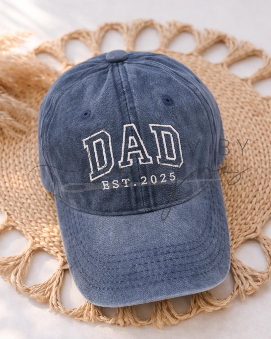 Single Ball Cap with adjustable strap featuring an embroidered DAD est date logo - placed on a woven placemat for photo (etsy image id: 7613545978)