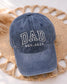 Single Ball Cap with adjustable strap featuring an embroidered DAD est date logo - placed on a woven placemat for photo (etsy image id: 7613545978)