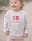 A little girl featured wearing a light gray sweatshirt with the words "BIG sister" embroidered in red. The sweatshirt is customizable and is a highly sought brand, rabbit skins (etsy image id: 7657080349)