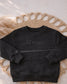 A simple laid out image of a rabbit skins black crewneck featuring an embroidered "lil man" on the front of his chest with a monochrome coloring thread (etsy image id: 7660006889)